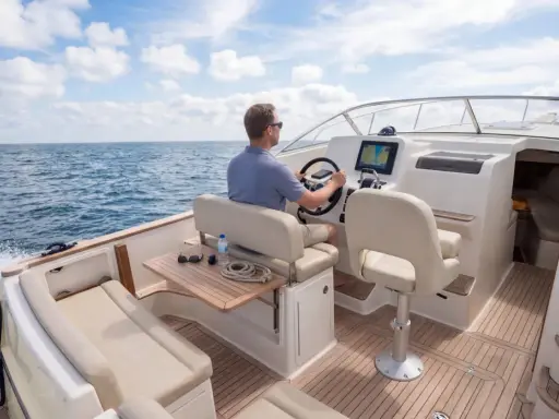 Un homme pilote un bateau sur la mer, le tableau de bord affiche le numéro MMSI.