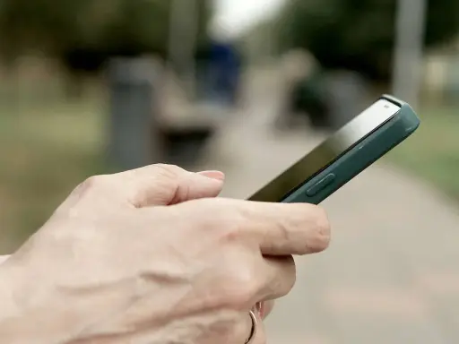 Dłoń trzyma smartfon Huawei, być może przygotowując się do wykonania hard reset.