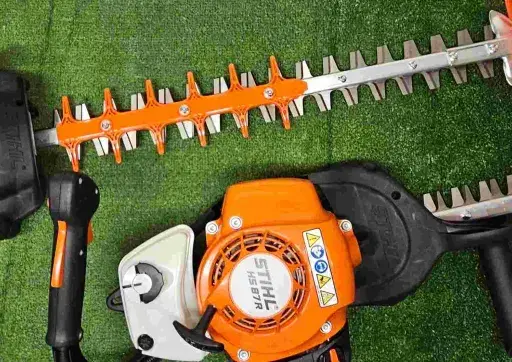 Deux taille-haies Stihl orange et noirs, prêts pour le taillage de haie.