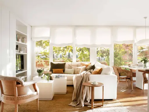 Salón luminoso con muebles blancos y madera. El color de pared ideal para este estilo es un blanco cálido que realza la calidez de la madera y la frescura del blanco.