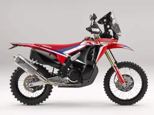 Czerwono-biały motocykl Honda CRF 450 Rally z czarnymi akcentami, gotowy na rajdowe wyzwania.