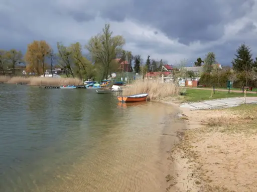 Spokojna tafla wody, łodzie przy brzegu i piasek tworzą malowniczy krajobraz. Czy to najczystsze jezioro w Polsce?