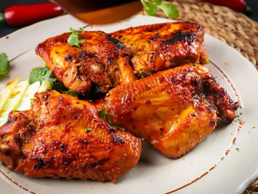 Saftige Hähnchenflügel, perfekt gegrillt, ein köstliches pollo fino rezept. Garniert mit frischer Petersilie und knackigem Sellerie.
