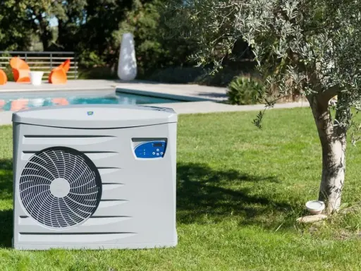 Pompe à chaleur pour piscine, élément clé d'un schéma de filtration performant, installée sur une pelouse verdoyante près d'une piscine.