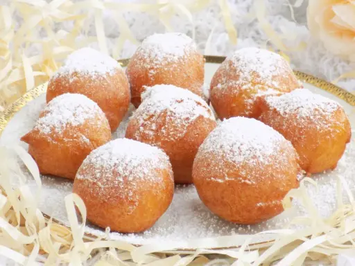 Puszyste paczki z serka homo, posypane cukrem pudrem, kuszą swoim wyglądem. Idealne na deser lub słodką przekąskę.