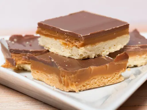 Carrés de shortbread millionnaire au caramel beurre salé, recouverts de chocolat noir. Un délice gourmand.