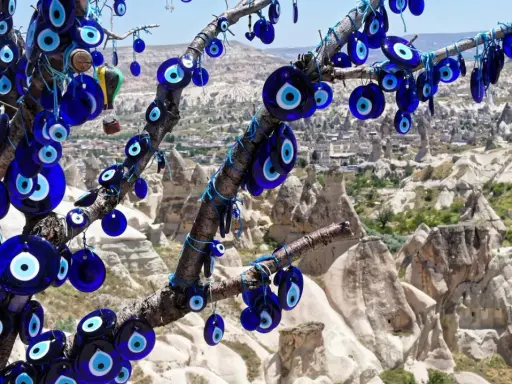 Ein Baum voller blauer Glasaugen, die wie ein arabisches Auge vor der Felslandschaft von Kappadokien schützen.