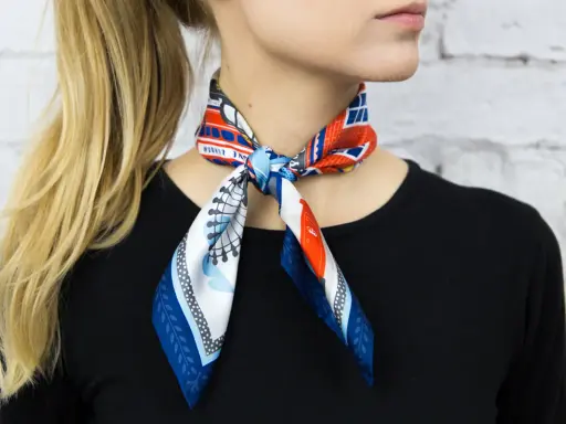 Elegancka gawroszka jak nosić? Wzorzysty apaszek z motywem Londynu zawiązany na szyi, dodaje uroku stylizacji.