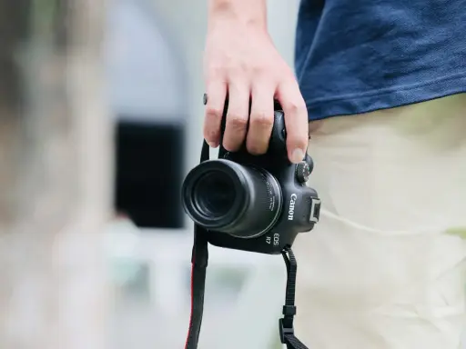 Dłoń trzyma aparat Canon EOS R7, gotowy do uchwycenia chwili. Jego matryca w aparacie zapewni doskonałą jakość zdjęć.