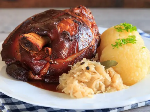 Knusprige Schweinshaxe mit Klößen und Sauerkraut. Ein köstliches Schweinshaxe Rezept für Genießer.