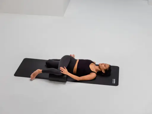 Frau mobilisiert mit Foam Roller die ISG-Region in Rückenlage.