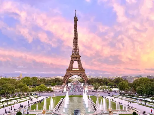 Eiffelturm im Abendrot, ein Muss, wenn man in Paris ist. Brunnen und Menschen beleben die Szenerie.