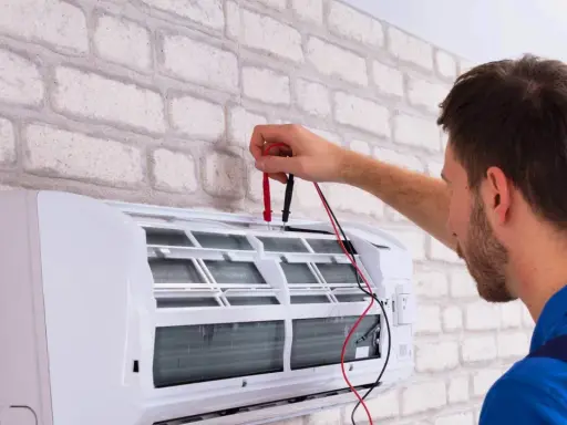 Technik sprawdza klimatyzację, przygotowując ją do dezynfekcji. Czyste powietrze w domu to podstawa.