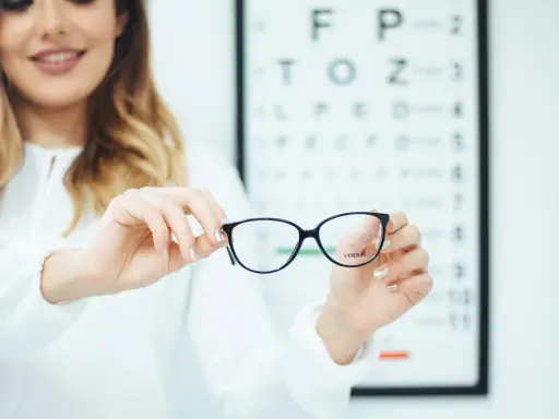 Okulista prezentuje okulary podczas badania wzroku.