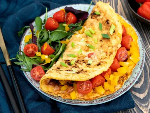 Pyszny omlet fit z pomidorkami i papryką, podany z sałatką. Idealny na zdrowe śniadanie.