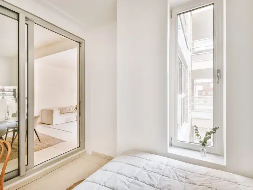 Puerta corredera de cristal que da a un salón. Explora los tipos de cristales para puertas de interior y cómo iluminan tu hogar.