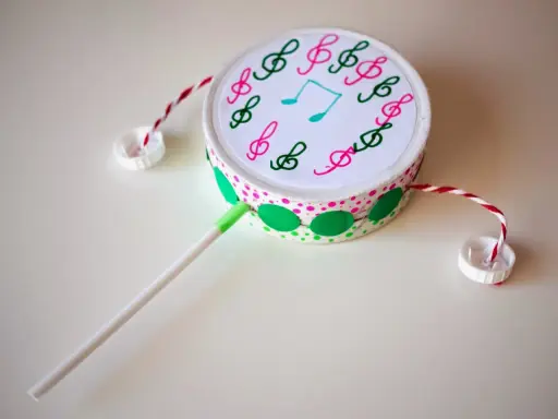 Tambor decorado con notas musicales, hecho con **instrumentos con materiales reciclados**. Ideal para crear música.
