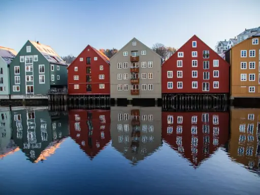 Kolorowe domy nad wodą, odbijające się w spokojnej tafli. Idealne miejsce na pracę z norweskim, podziwiając architekturę.