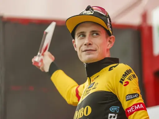 Jonas Vingegaard, strahlend mit einer Trophäe, trägt sein gelbes Jumbo-Visma Trikot.