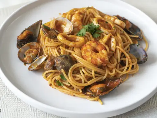Espaguetis a la marinera con gambas, mejillones, calamares y almejas, todo bañado en una rica salsa de tomate.