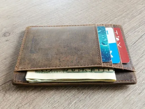 Brązowy, skórzany portfel z kartami i banknotami. Dowiedz się, jak wyczyścić skórzany portfel, by wyglądał jak nowy.
