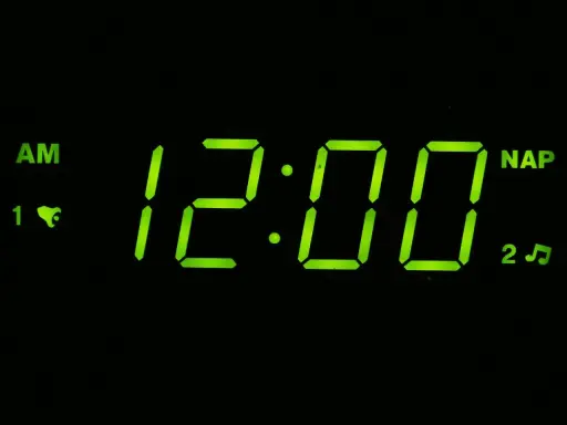 Budzik pokazuje 12:00 AM. To oznacza północ, początek dnia.