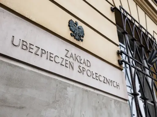 Tablica z napisem "Zakład Ubezpieczeń Społecznych" i godłem Polski. Zastanawiasz się, jak urlop bezpłatny wpływa na ZUS?