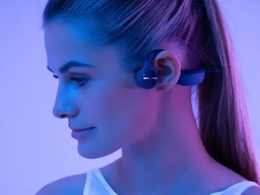 Une femme porte un casque à conduction osseuse. Ce type de casque peut présenter un danger si l'on n'est pas attentif à son environnement.