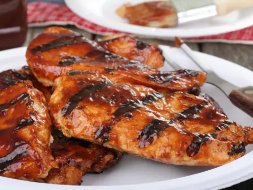 Soczysty kurczak z grilla elektrycznego, polany sosem BBQ. Idealny na letnie popołudnie, a jak długo grillować kurczaka na grillu elektrycznym? To pytanie, na które odpowiedź znajdziesz w przepisach!