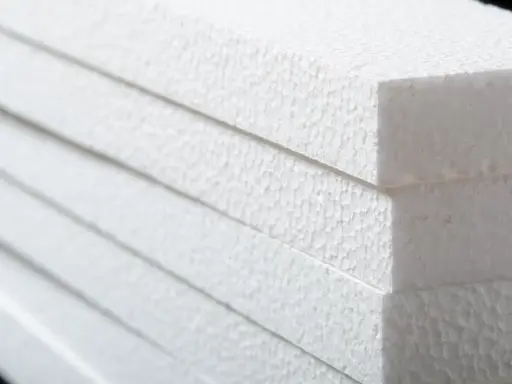 Stapel weißer Styroporplatten, bereit für die Isolierung. Die feine, körnige Textur des Materials ist gut sichtbar.