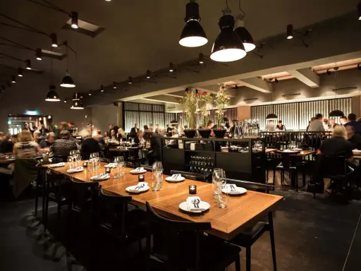 En elegant restaurang i Stockholm med dukade bord och gäster. Kanske en kväll med live musik stockholm?