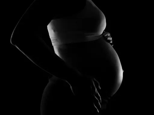 Silhuett av en gravid kvinna som håller sin mage. Bilden kan associeras med vena cava syndrom gravid.