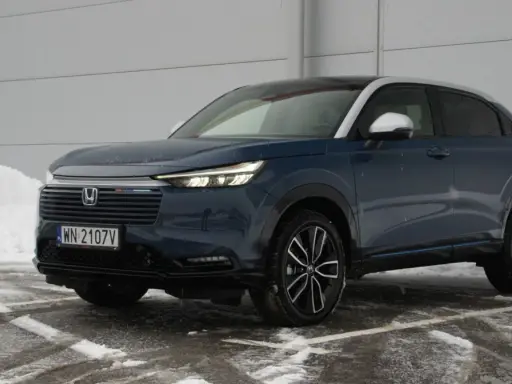 Ciemnoniebieski Honda HR-V na tle śniegu i szarej ściany.