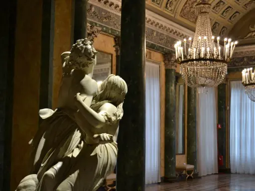 Scultura in marmo in una sala sontuosa con lampadari di cristallo. Un'idea per i musei gratis a Milano.