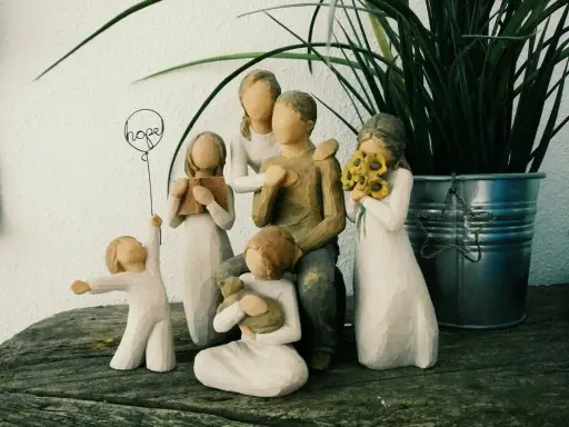 Eine griechische Familie aus Figuren: Vater, Mutter, zwei Mädchen, ein Junge und ein Baby. Ein Mädchen hält ein Buch, ein anderes Sonnenblumen.