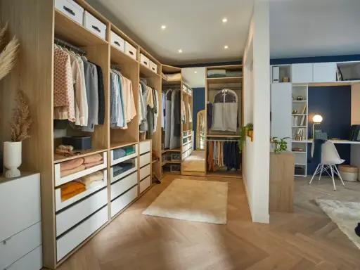 Un dressing aménagé pour un dressing à faire soi même, avec des étagères en bois, des tiroirs et des vêtements bien rangés.