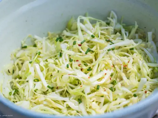Frischer spitzkohl salat mit Schnittlauch und Chili-Flocken, appetitlich in einer Schüssel angerichtet.