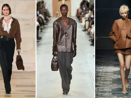 Modelli sfilano con outfit in colore testa di moro, mostrando abbinamenti eleganti con pantaloni neri, grigi e completi in pelle.