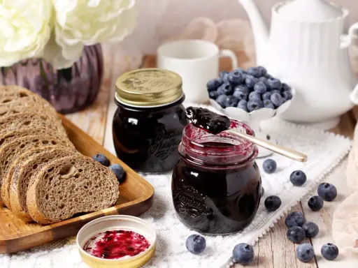 Un petit-déjeuner gourmand avec du pain de campagne, des myrtilles fraîches et une délicieuse confiture de myrtilles.