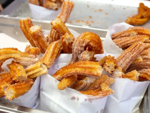 Deliciosos churros recién hechos, cubiertos de azúcar. Una guía visual de como hacer churros perfectos.