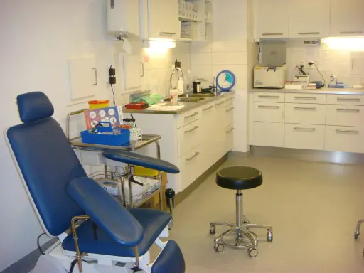 Blå undersökningsstol och medicinsk utrustning i ett kliniskt rum. Förberedelser för att testa för tyfoidfeber.