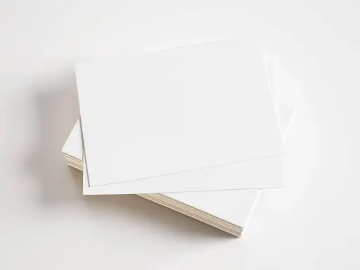 Stos białych kartek, gotowych do zadrukowania. Idealne na wizytówki, zaproszenia lub inne materiały promocyjne z kartonu GC1.