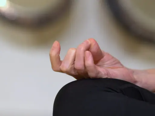 En hand i meditationsställning, fingrarna böjda i en gest som påminner om sa ta na ma. Lugn och ro.