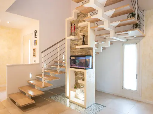 Moderna scala interna in legno e metallo con acquario integrato. Il design innovativo suggerisce un interessante costo scala interna.