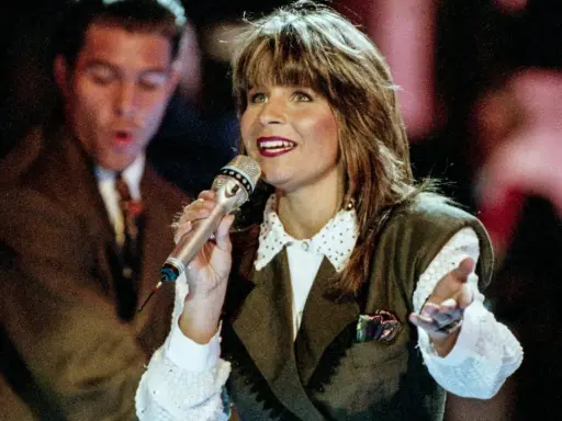 Carola sjunger, en av de svenska bidrag som vunnit Eurovision. Hon håller en mikrofon och gestikulerar.