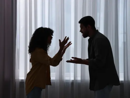 Siluetas de una pareja discutiendo apasionadamente. Ella gesticula con las manos, él la mira fijamente. ¿Será que porque atraigo a personas con problemas?