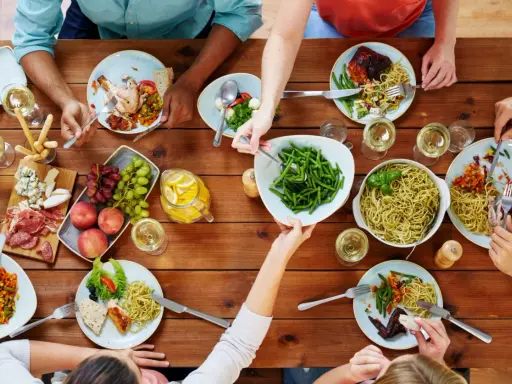Un repas convivial entre collègues : pâtes, poulet rôti, salade, fruits et charcuterie. Une belle idée repas entre collègues travail.