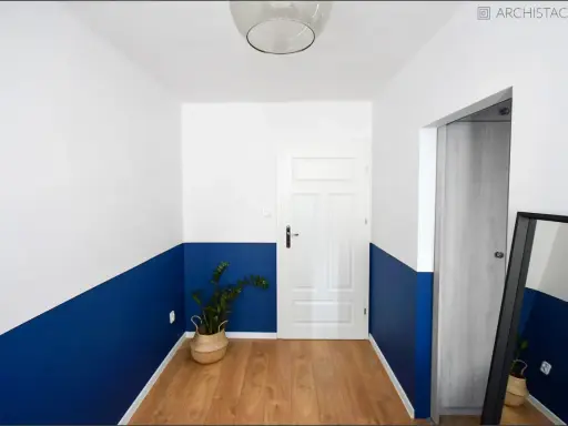 Nowoczesny korytarz z dwukolorową lamperią. Zobacz, jak pomalować lamperie w ciekawy sposób, tworząc geometryczne wzory.