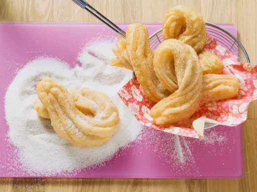 Churros dorés saupoudrés de sucre, prêts à être dégustés. Une délicieuse recette churros pour le plaisir des gourmands.