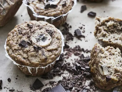 Saftiga bananmuffins med chokladbitar och en bananskiva på toppen. Perfekt för ett banan muffins recept.